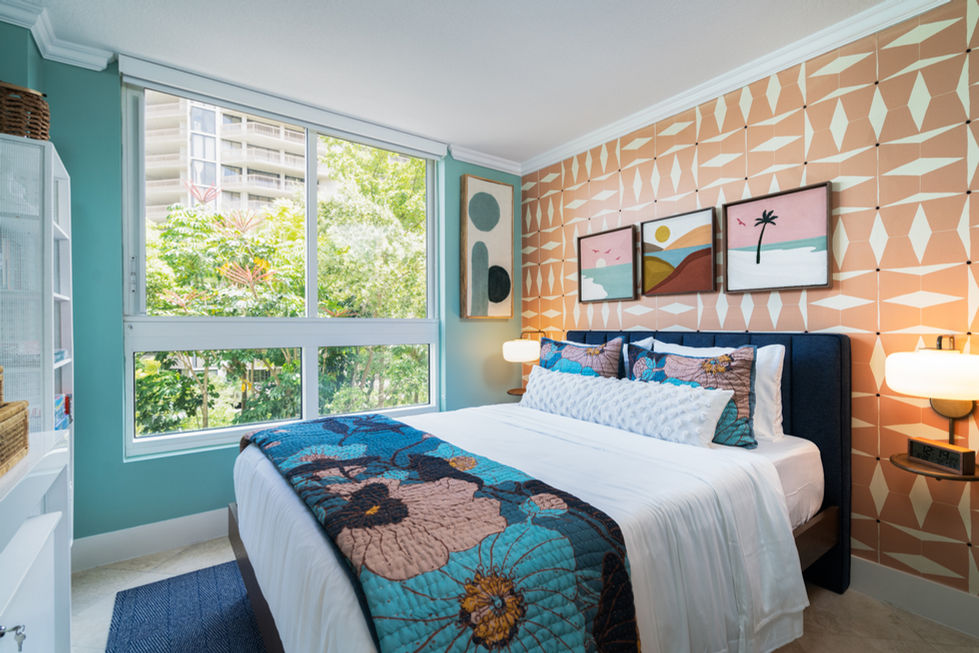 Bright bedroom with layered blue textiles, outdoor views, and calm styling by a Miami interior designer