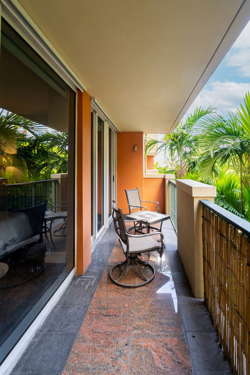 Cozy outdoor balcony with seating and tropical views, styled as part of a Miami modern interior design project