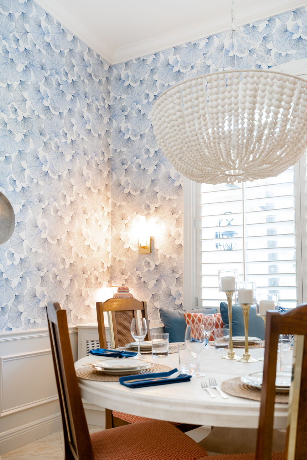 Elegant dining area with textured wallpaper, sculptural chandelier, and natural light, styled for a refined interior in Miami