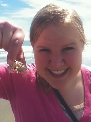 Missy enjoys the beach & a crab