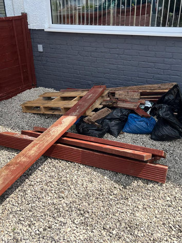 old timber and pallets on gravel outside front window of house