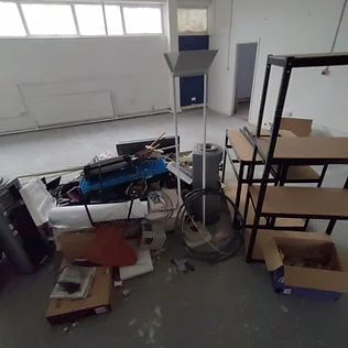office space with a pile of broken office shelving and electrical equipment piled in the centre of the floor