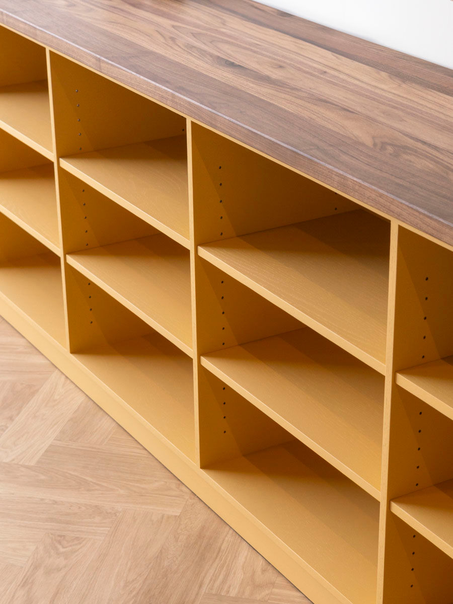 Open vakken van een gele boekenkast