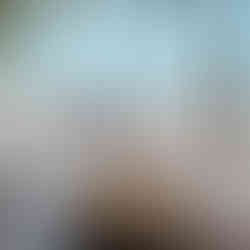 A coconut cream on a table with a sandy beach and calm sea in the background in Con Dao.