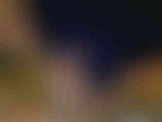 Colorful Mediterranean-style buildings and a lit clock tower in Sunset Town, Phu Quoc at night.