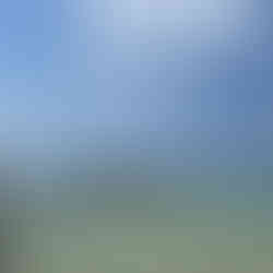 People standing and swimming near a wooden pier in the shallow, transparent sea at Ham Rong, Phu Quoc under a bright blue sky.