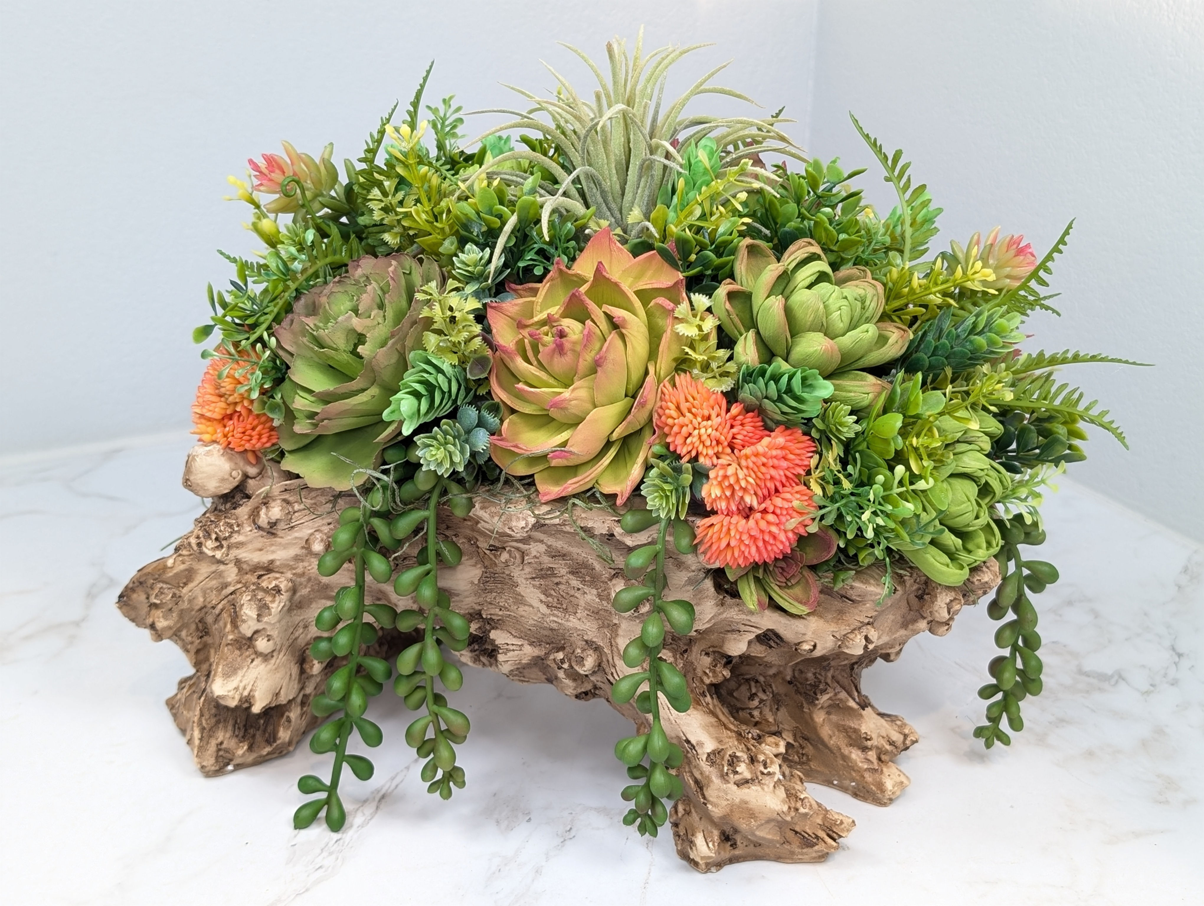 Faux log filled with wooden succulents