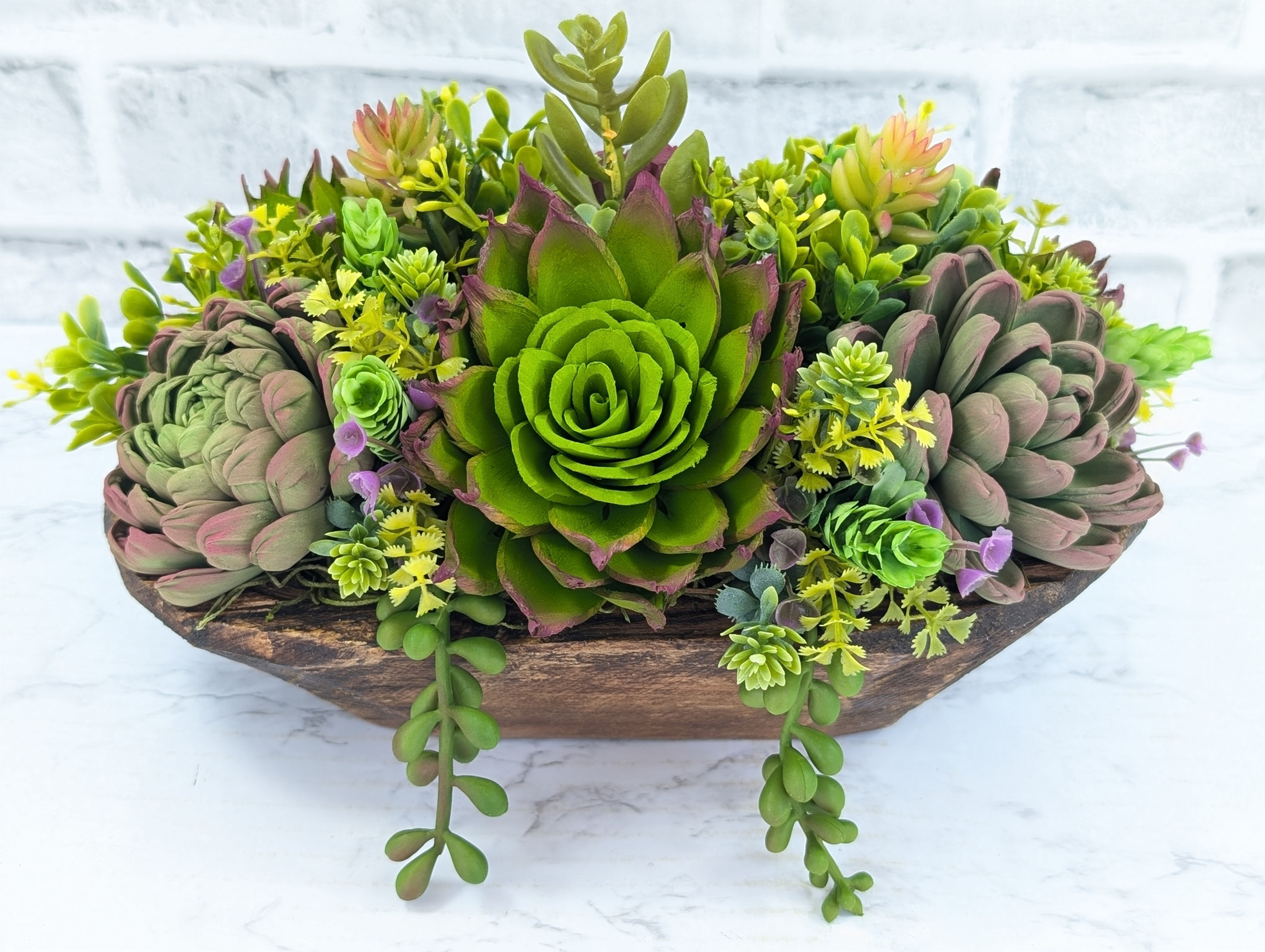 Succulent arrangement in wooden bowl