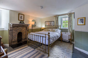 A bedroom in a 1930's style with a metal framed bed