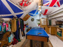 A games room with a ping pong table, flags and dressing up clothes