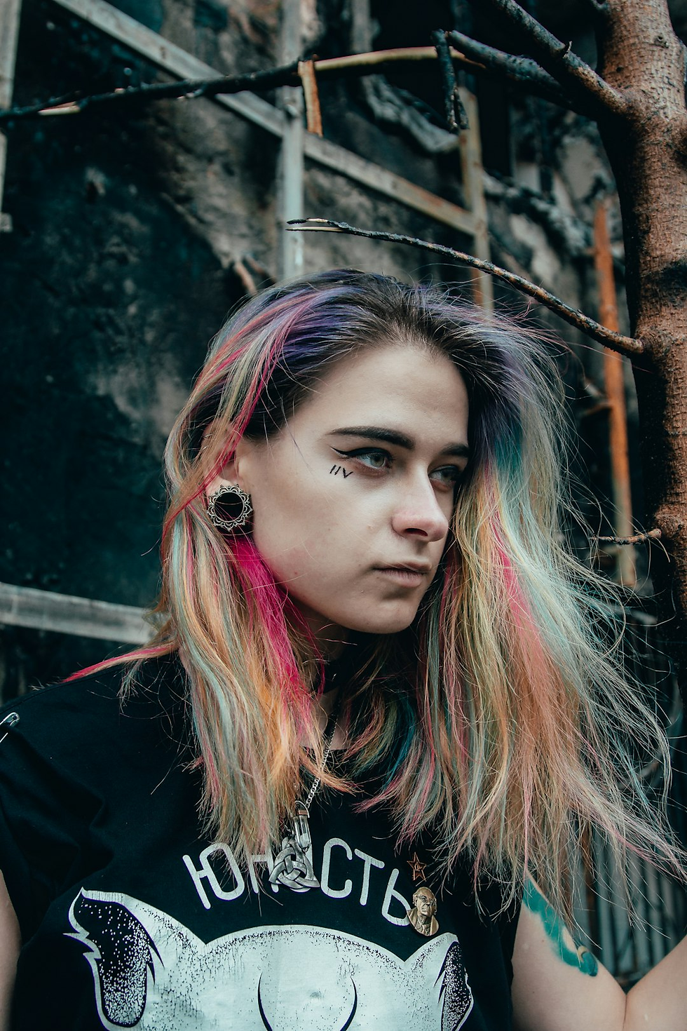 Rainbow-haired punk woman with gauges and a cheek tattoo representing rebellion in digital design.