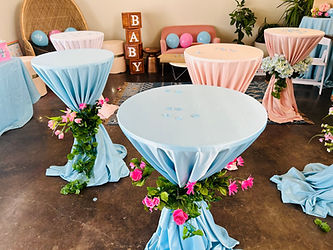 Baby shower setup with blue and pink tables, 'BABY' blocks