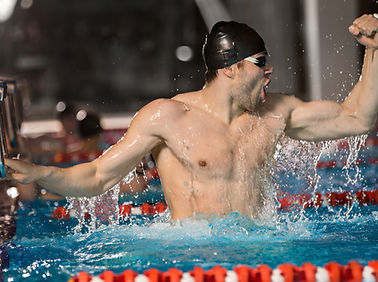happy-male-swimmer-holding-starting-block.jpg