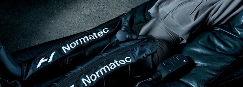 Woman using Normatec compression therapy on her hips and legs.