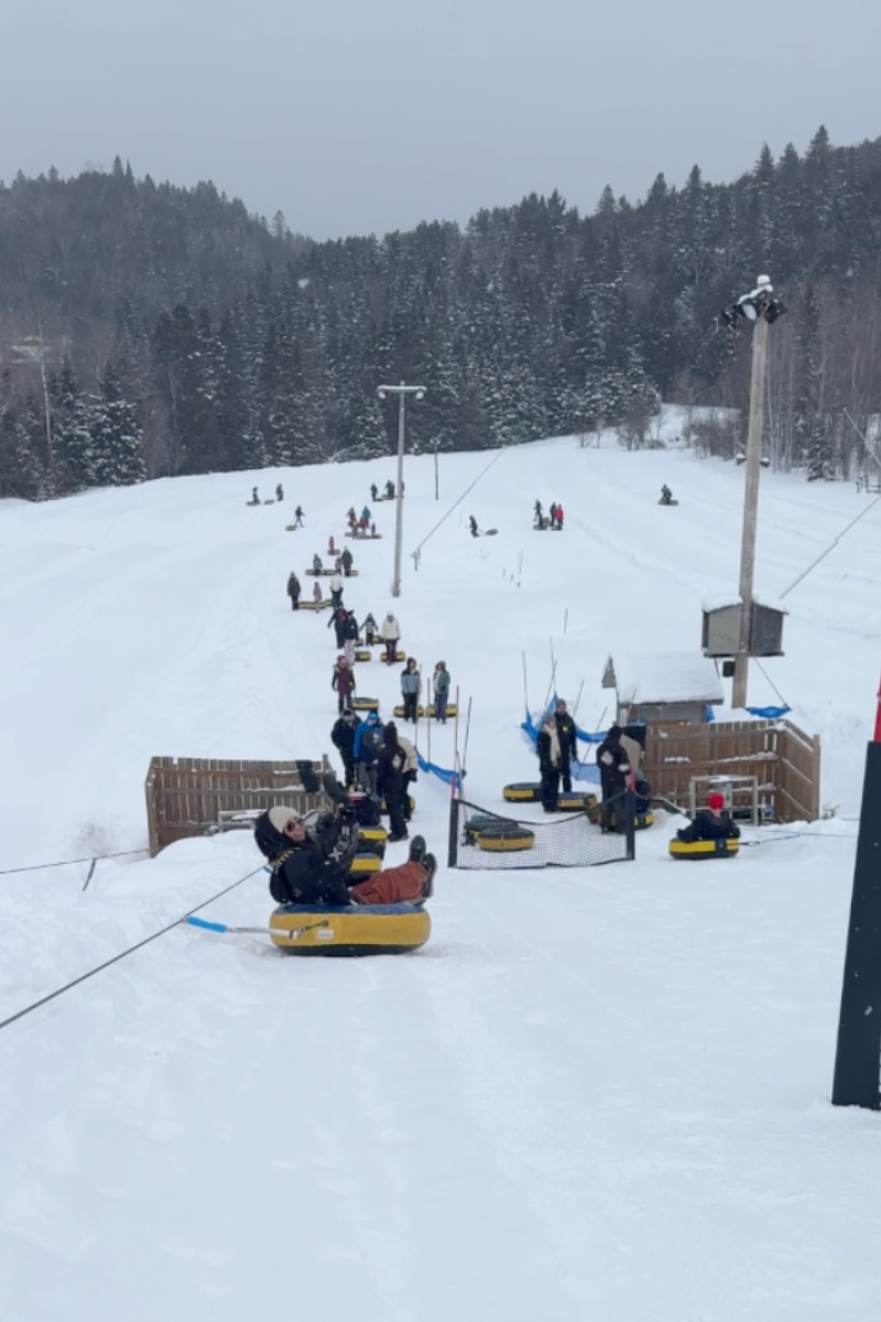 Snow tubing hill at Aventures Neige in Mont-Tremblant with visitors riding yellow tubes down snowy s