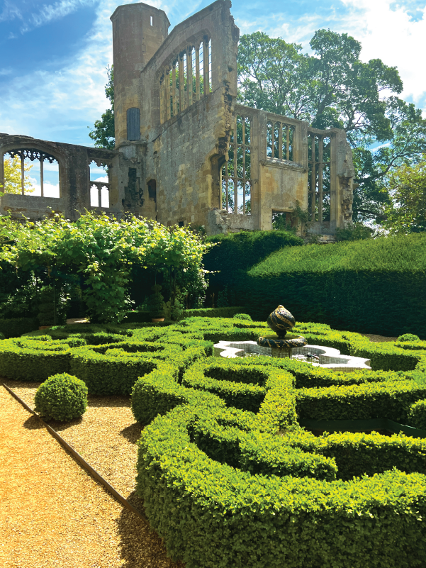 Ornate hedge maze-style garden with geometric patterns and a small water feature at Sudeley Castle.