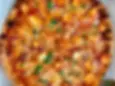 Halal Butter Chicken Pizza from Chicago Pizza & Pasta in Irving. Butter chicken simmer sauce, onion, garlic, green bell pepper, ginger, cilantro