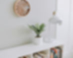 白色書架上擺放著書籍、盆栽和白色檯燈。淺灰色的牆壁上懸掛著一座木質時鐘_SpaceUp收納軟裝好生活