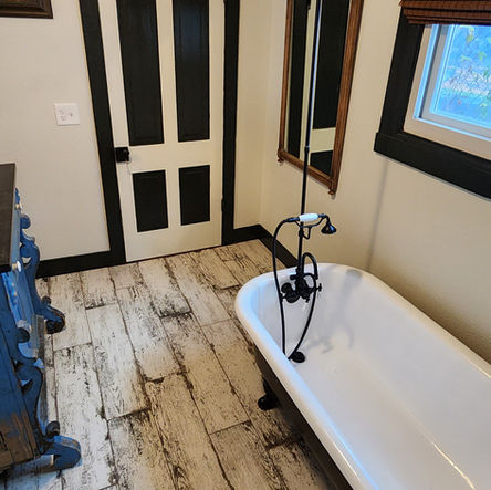 Renovated bathroom: clawfoot tub, wood floors