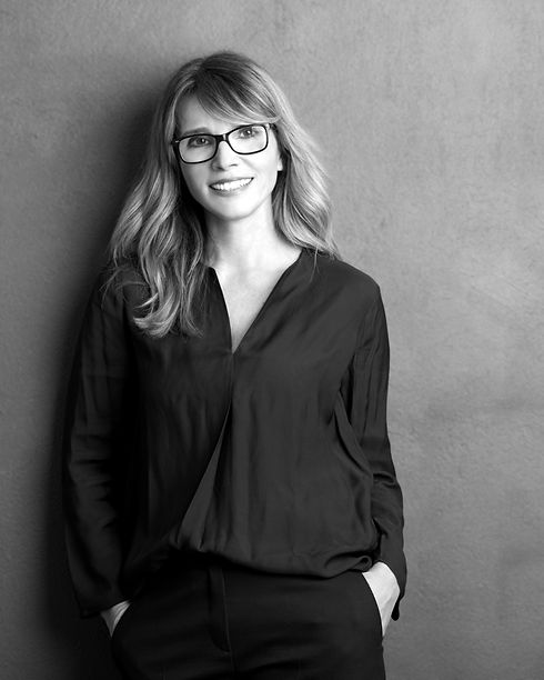 woman with glasses , shirt and trousers smiling