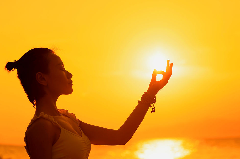 Silhouette of woman meditating at sunset