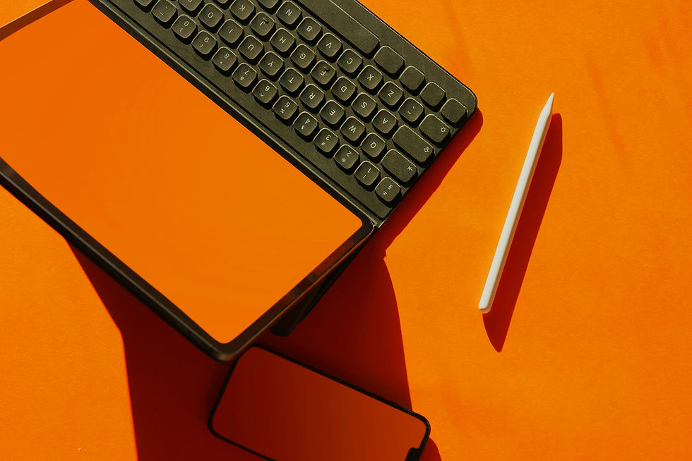 Laptop and pen on orange desk