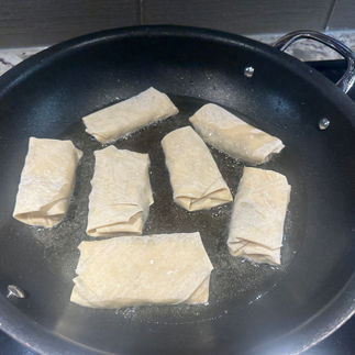 Venison egg rolls frying in canola oil
