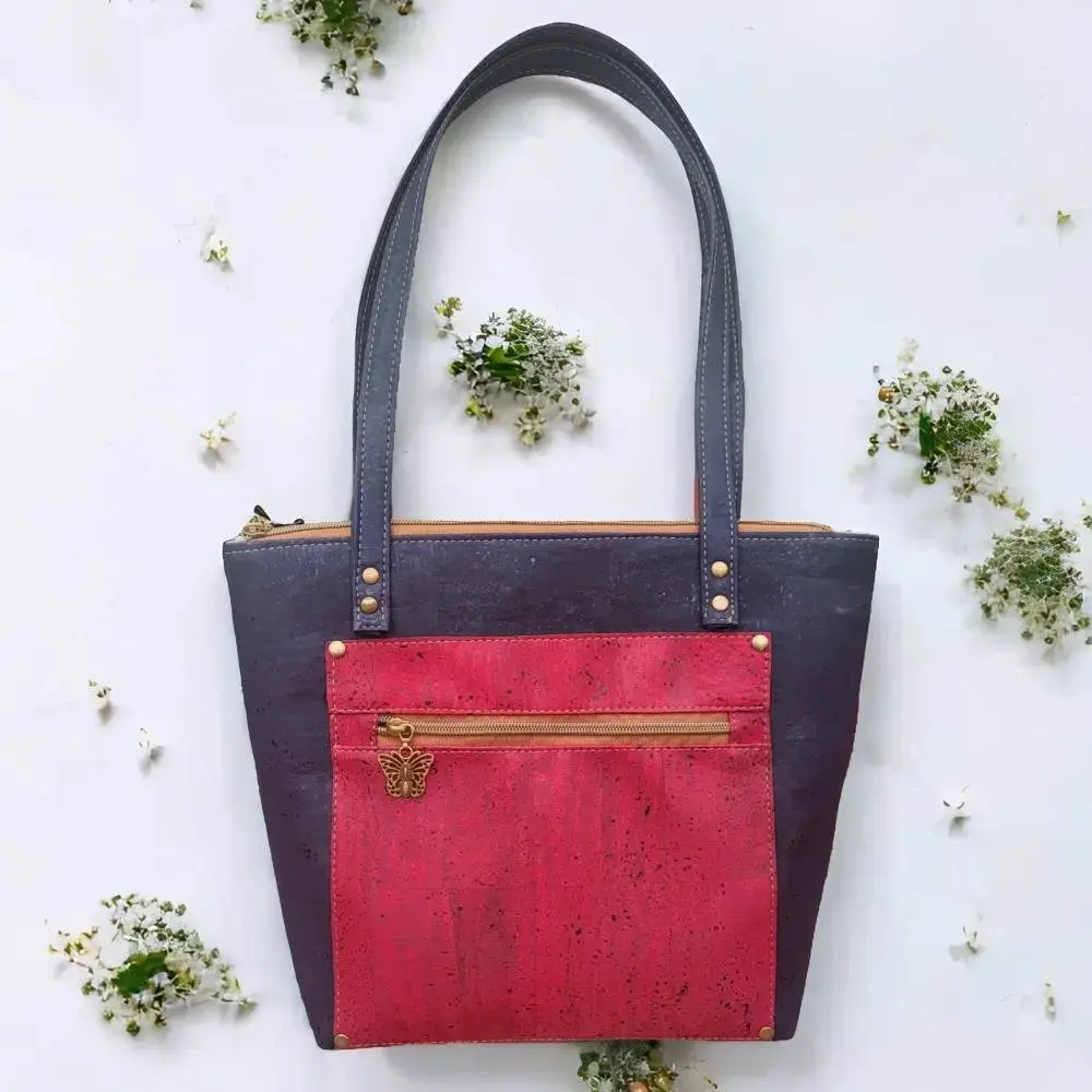 Blauwe shopper tas van kurk tussen de bloemen