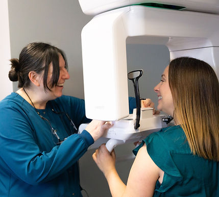 Patient and Staff standing by X-ray machine
