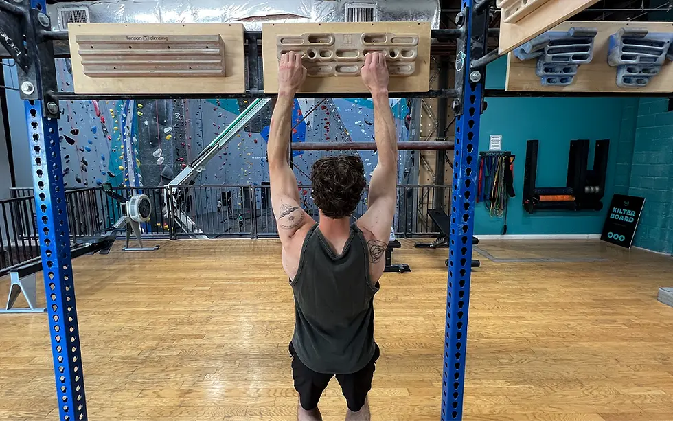 A climber hangs off of a hangboard. A hangboard is a rock climbing training tool with multiple grips to train for different terrains.