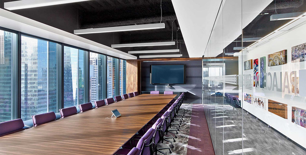A large conference room with purple chairs and a tv, with great lighting. 