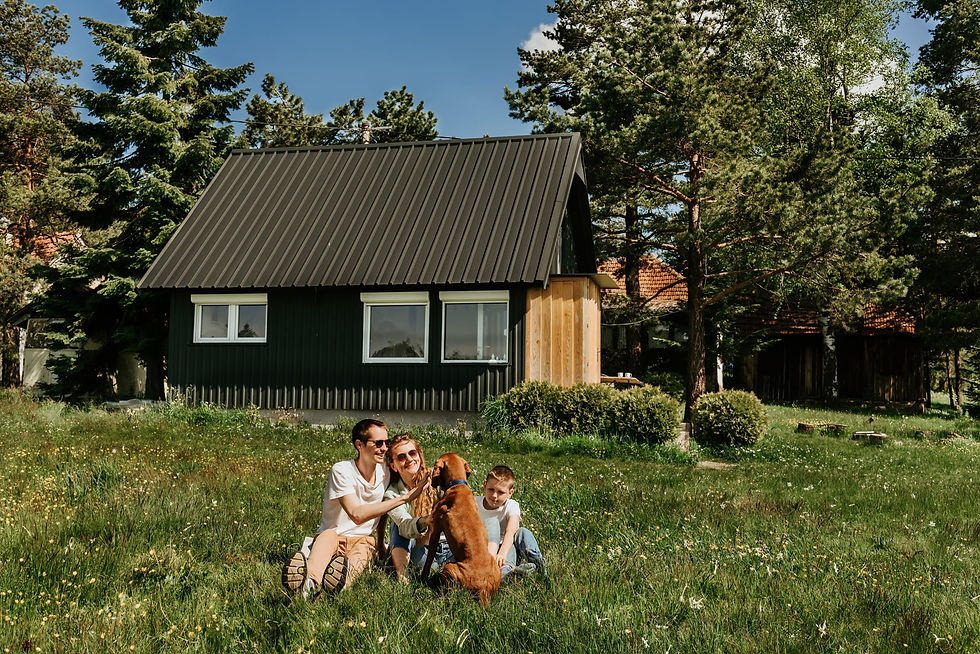 Happy Family with their dog in front of their metal roof home in North Bend Washington