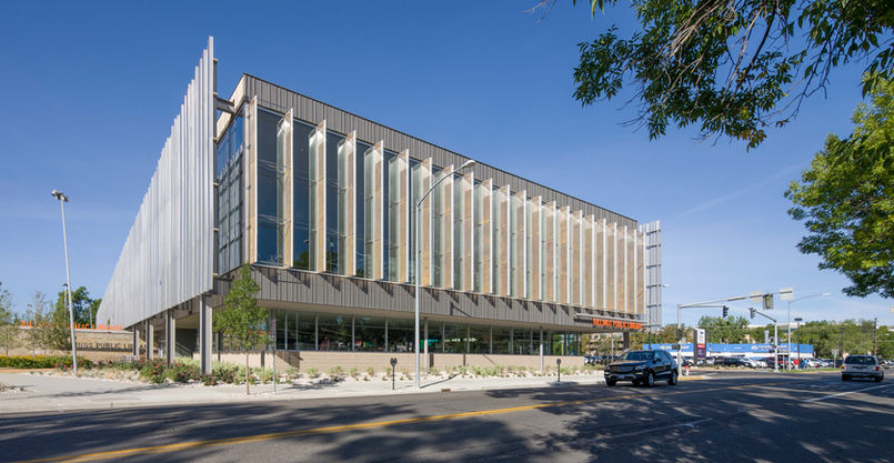 Modern Montana commercial building with vertical metal panels featuring large glass windows and street-side landscaping