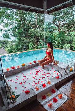 Girl in floral bath, with infinity pool in Seychelles Four Seasons