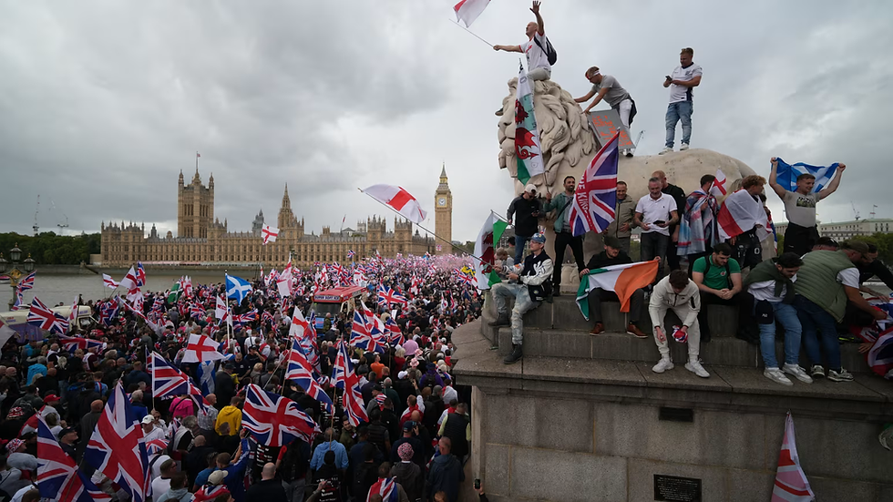 Protesters wave Union Jack and St George's England flags during the "Unite The Kingdom" rally on Westminster Bridge by the Houses of Parliament in London (Sept. 13, 2025) - Credits: Christopher Furlong/Getty Images