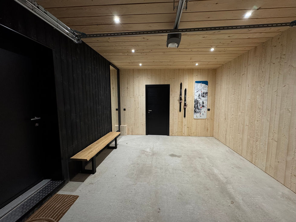 Intérieur d'un garage avec porte noire, banc en bois et skis accrochés. Altus 1124
airbnb auvergne chalet luxe altus 1124 murat le quaire sauna
