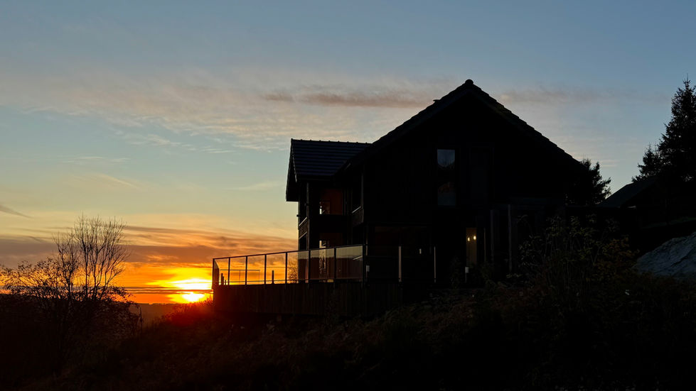 Silhouette maison au coucher du soleil, ciel orangé et Gallerie pour Altus 1124 airbnb auvergne chalet luxe altus 1124 murat le quaire sauna