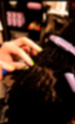 Eye-level view of a stylist performing interlocking on new locs