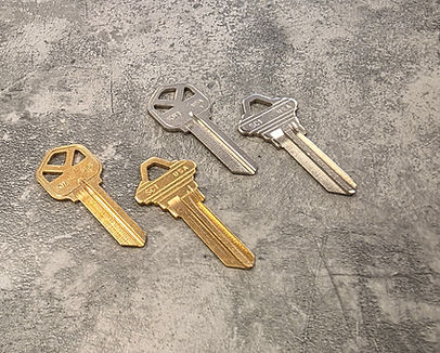 Standard gold and silver brass single-cut house keys displayed as options for basic key duplication.