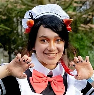 Maid Amber is posing in a garden in her uniform 

