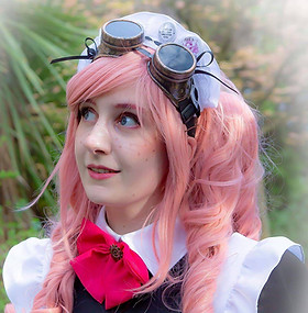 Maid Nonah is looking off camera and smiling. 