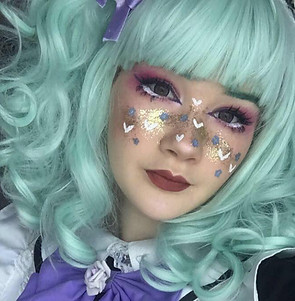 Maid Yui is smiling at the camera, Glitter and hearts adorning her nose. 