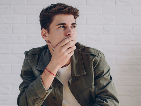 Man covering his mouth and thinking