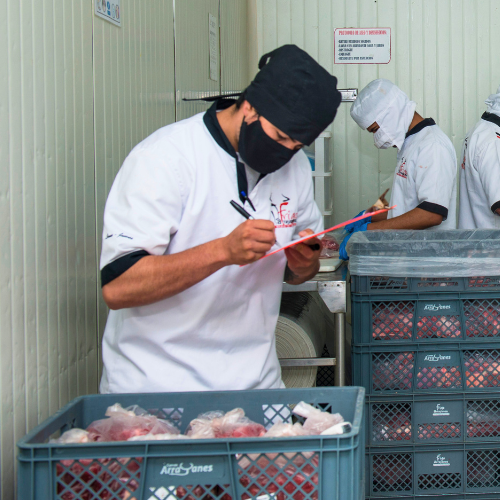 Una persona supervisando la calidad de la carne empacada al vacío