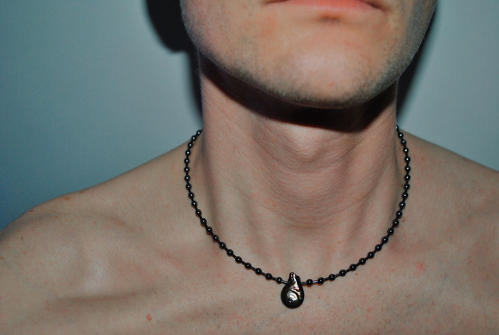 Miniatura: CZARNY NASZYJNIK Z PERŁĄ LATO RAW GALAXY na szyi modela prezentujący industrialny charakter biżuterii.