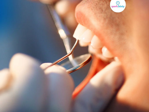 Close-up of a dental check-up, with a dentist's tools inspecting teeth. White gloves and shiny tools are visible. Bright lighting.