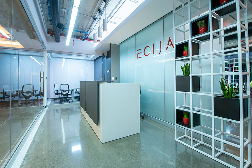 Modern office reception with the text ECIJA on the glass wall, architectural design.