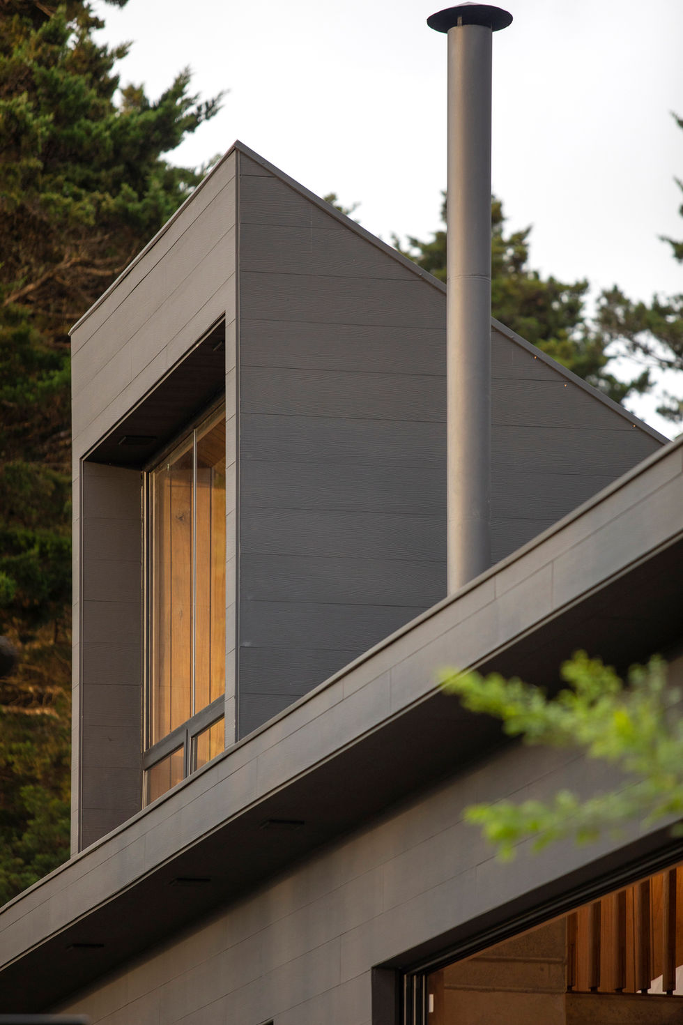 Modern architectural detail with angled roof and a large window, Casalvolone Arquitectura.