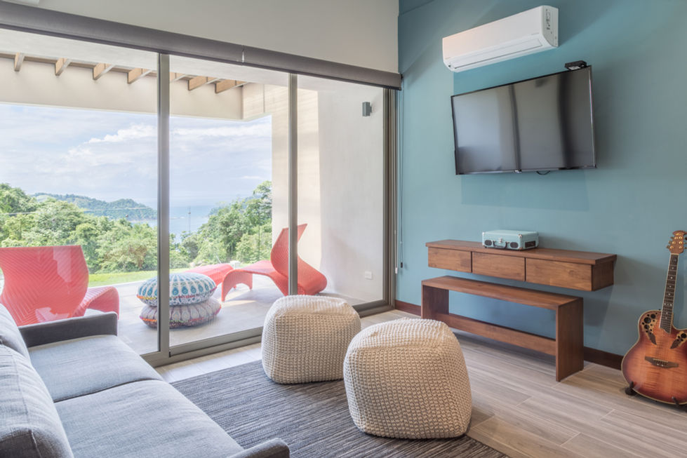 Modern living room with ocean view, TV, and two cozy beanbag chairs.