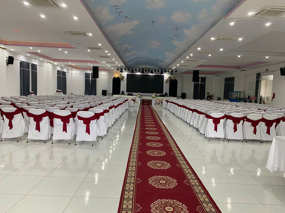 Ảnh thực tế bên trong hội trường Anh Thanh Đô Đô Lương Nghệ An, ghế trắng nơ đỏ và lối thảm đỏ dẫn lên sân khấu